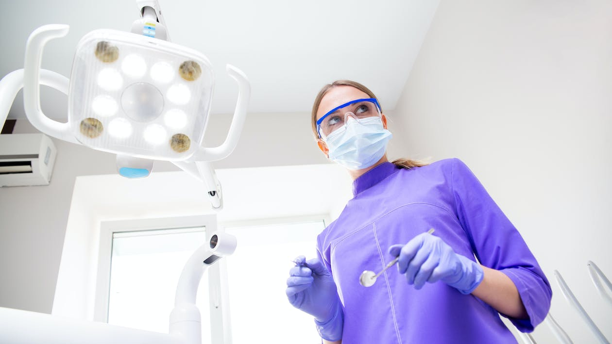 An oral surgeon holding dental tools