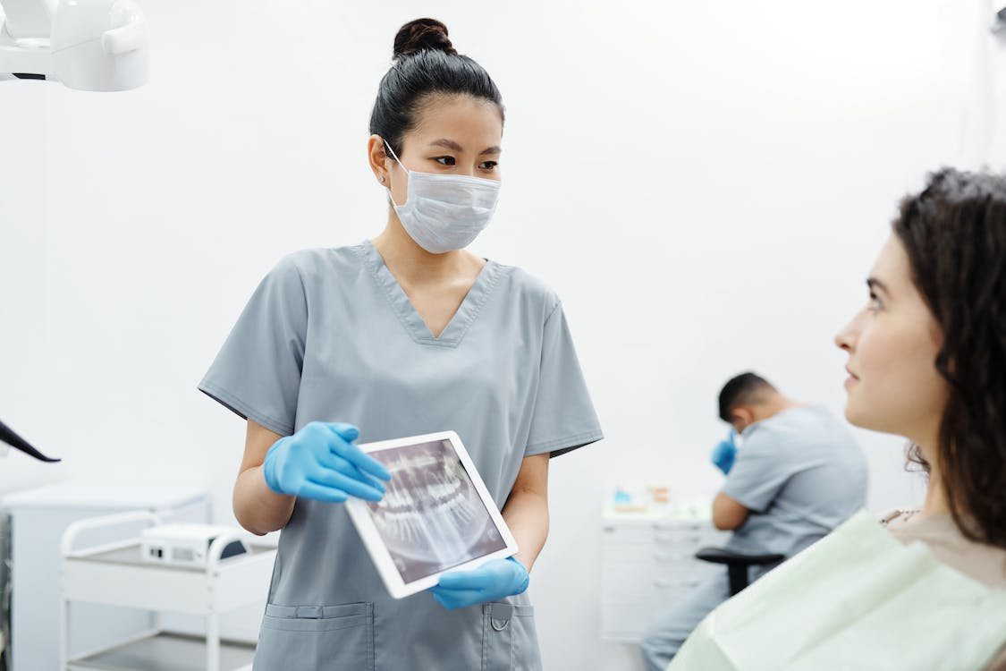 A periodontist showing a patient an x-ray