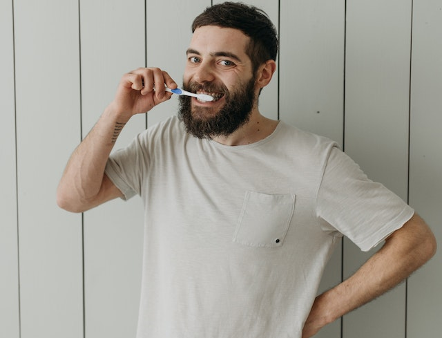 A guy brushing his teeth